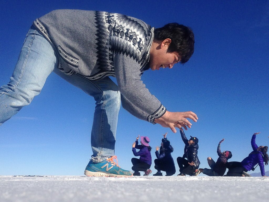 Giant person chasing other for funny photo at Salar de Uyuni, Salt Flats Bolivia