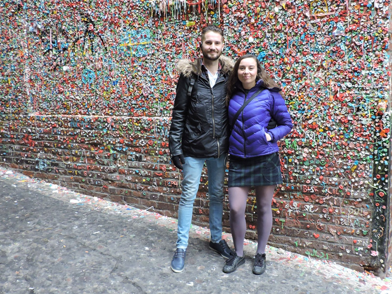 Couple standing in front of Gum Wall in Seattle