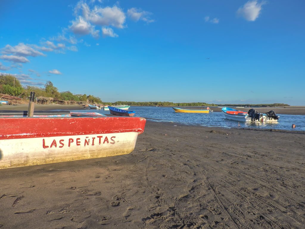 Stationed boat that says Las Penitas sits on beach