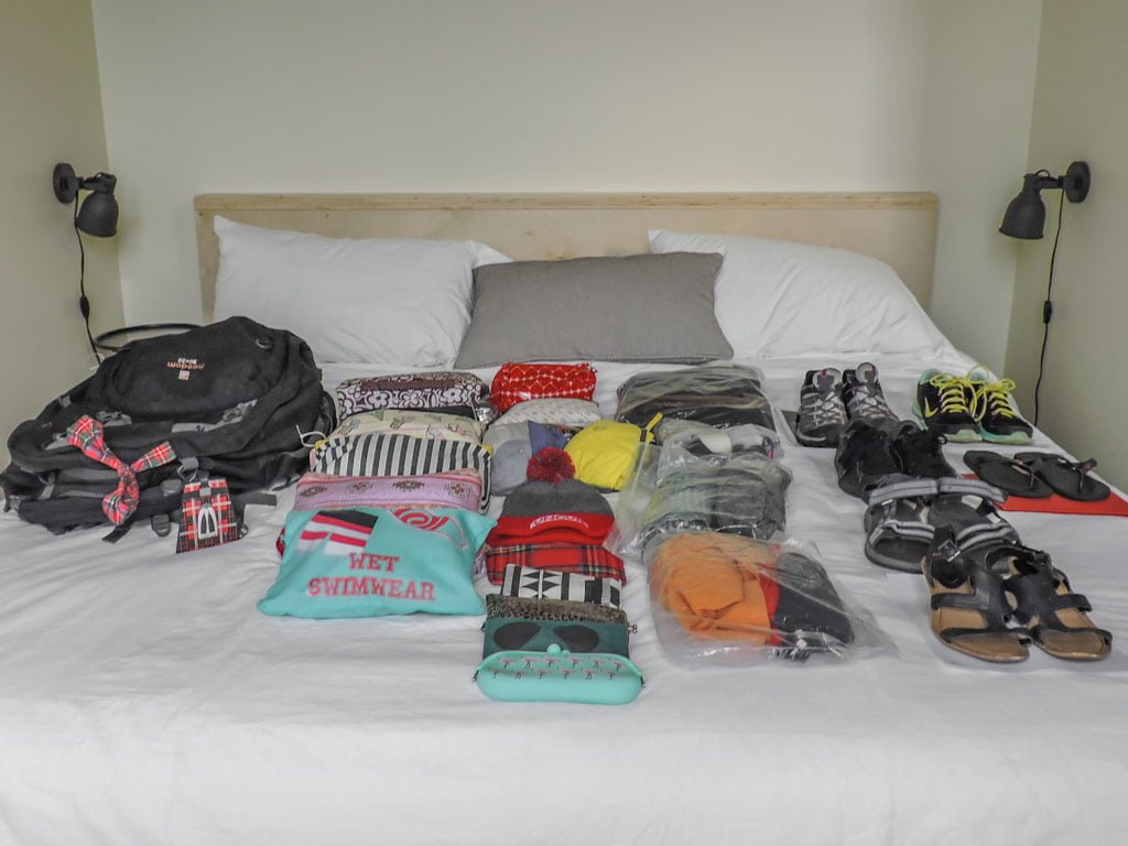 Clothes folded on bed for a packing list