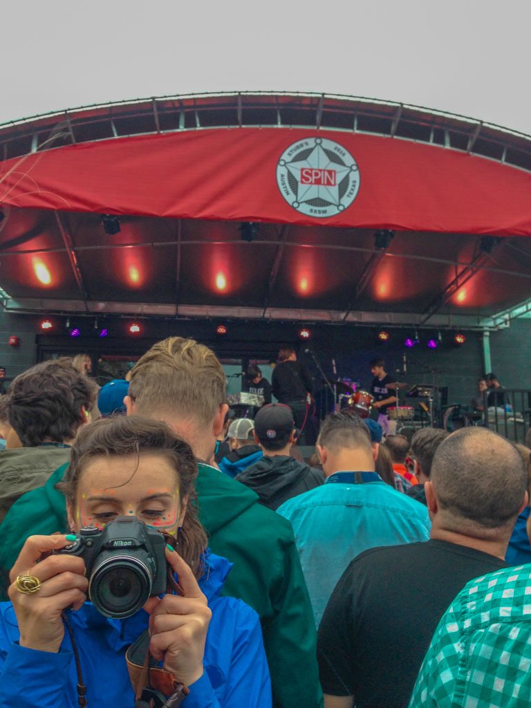 Woman taking phot at festival SXSW in Austin Texas using Nikon Coolpix p500 