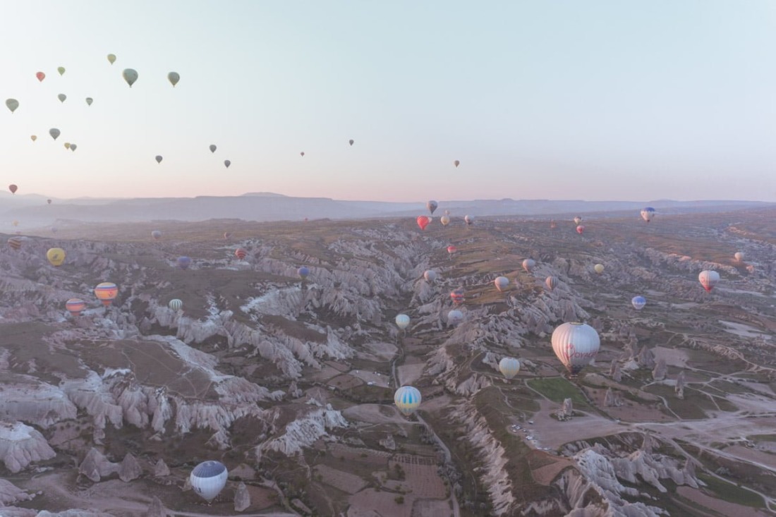 Hot air balloons flying over Cappadocia at sunrise