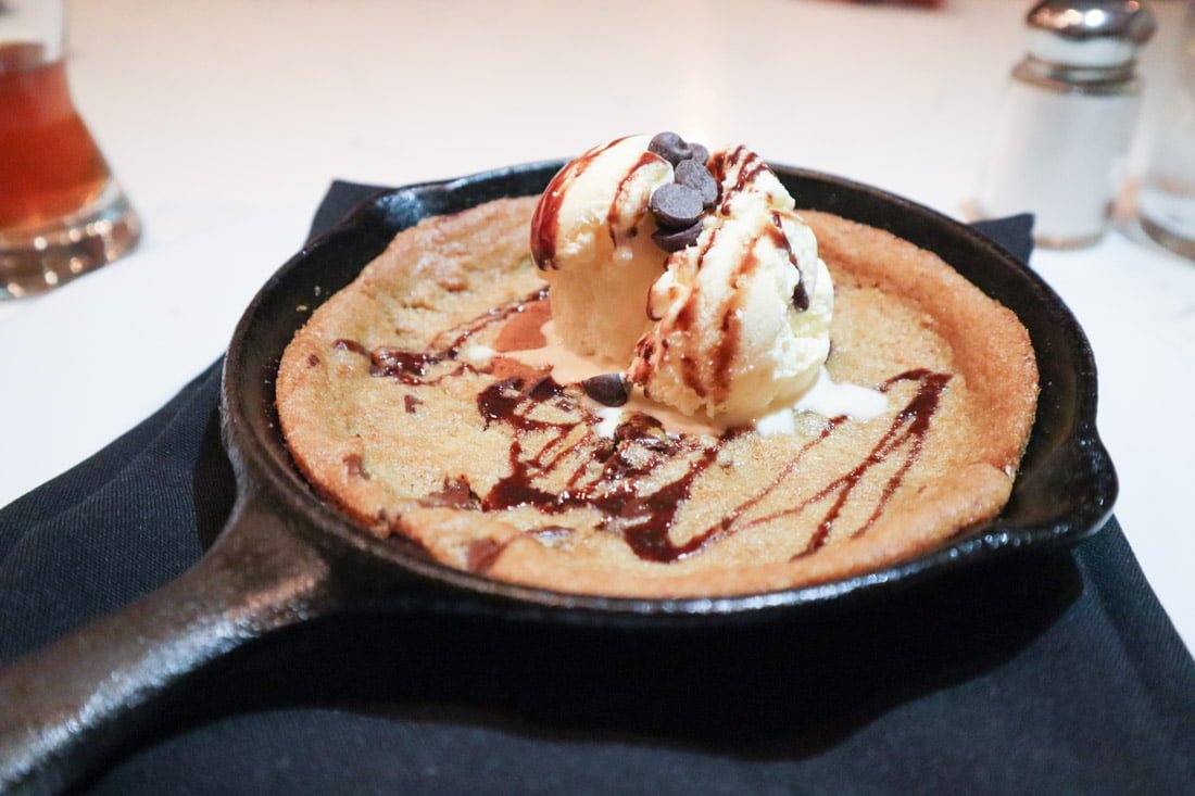 Cookie in a small frying pan with dollop of ice cream