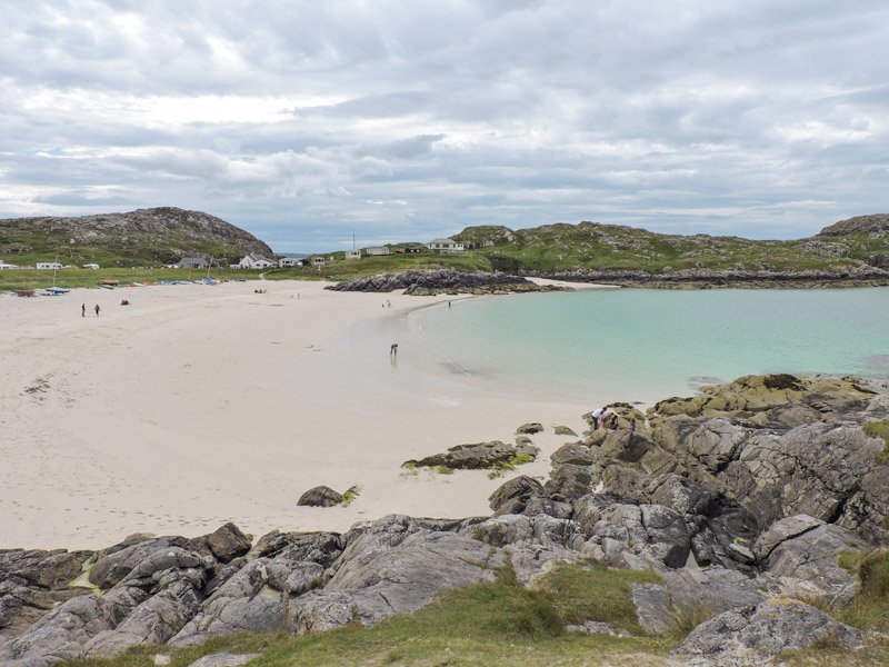 Achmelvich beach, blue sea, white sand, rocks, people North Coast 500 Scotland