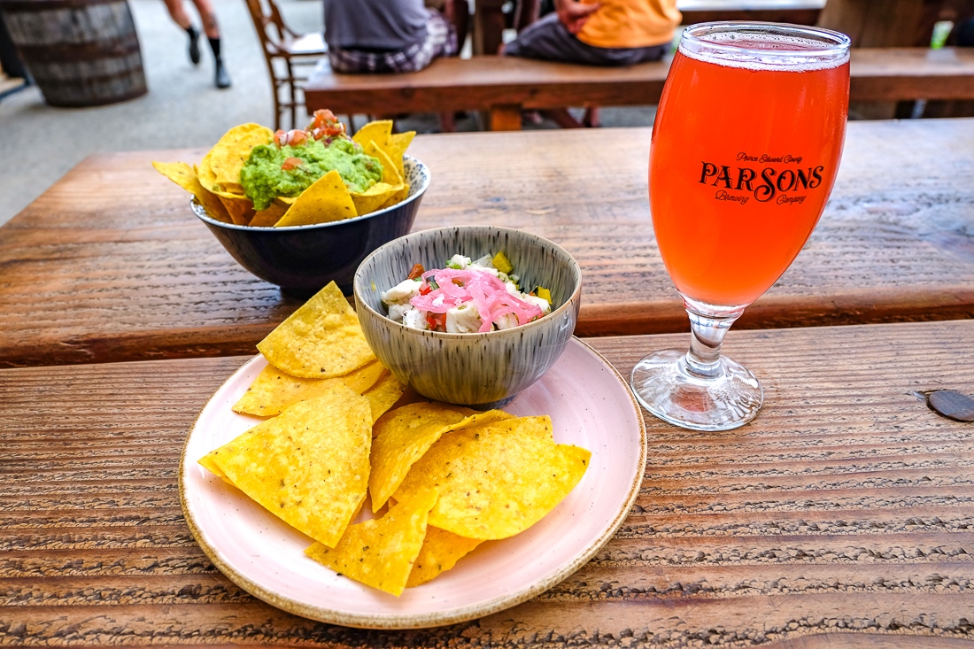 Dining in Prince Edward, nacho chips and dip with beer on table