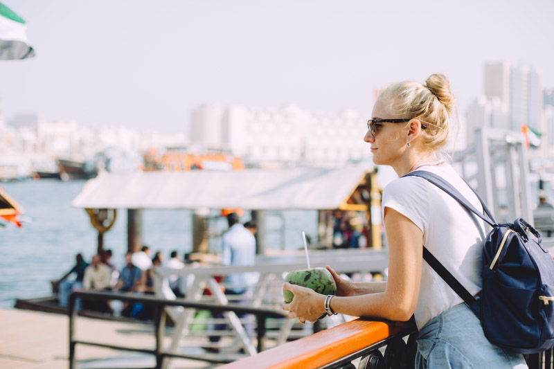 Dubai travel tips -Blonde women wearing sunglasses posing near a Dubai boat