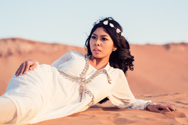 Girl in pretty white Caftans on desert sand