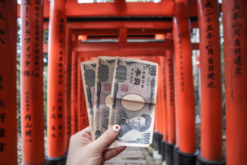 Japanese yen in front of Kyoto gate