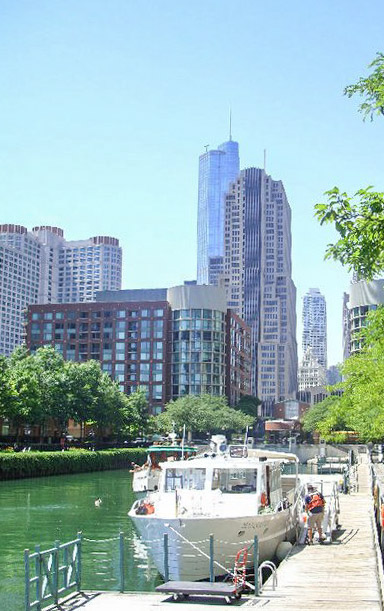 Chicago River with Boat Tour at the side of the sidewalk