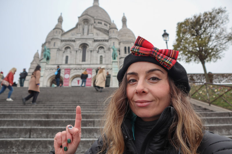 Woman pointing to Sacre-Coeur in Montmartre Paris