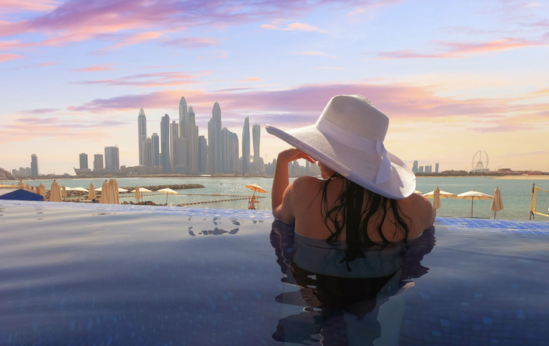 Dubai Skyline Woman With Hat in Pool