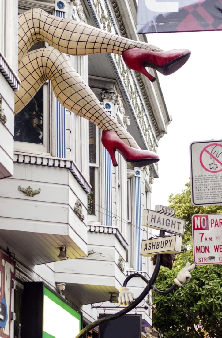 Haight Ashbury neighborhood in San Francisco, California, United States of America, a hippy area. View of a sculpture with large legs wearing fishnet stockings and red stiletto heel shoes out of a shop window.