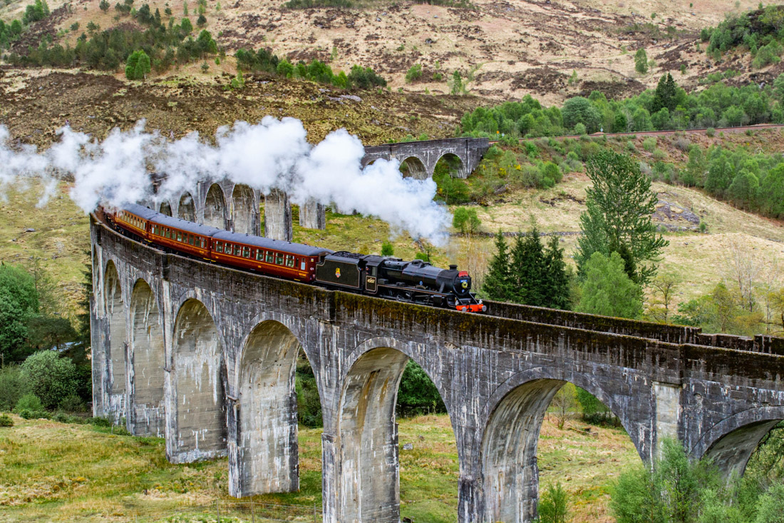 Jacobite Steam Train Hogwarts Express chugging over bridge in Scotland  