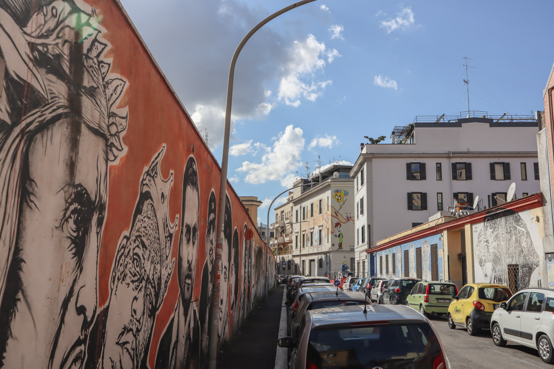 Wall of Fame by JB Rock orange wall with black and white portraits via dei Magazzini Generali street art_