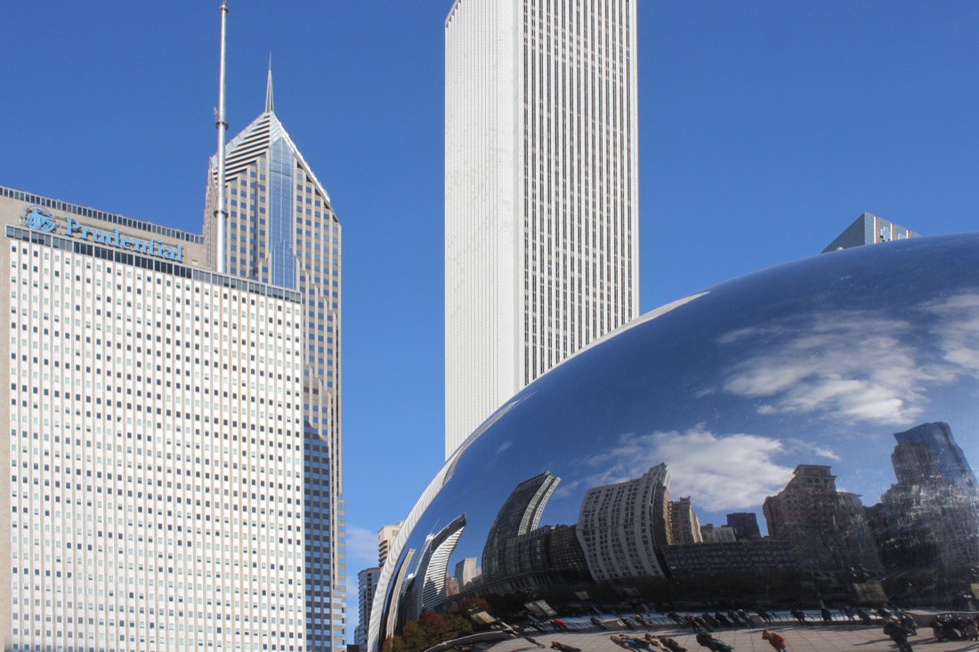 Cloud Gate silver Chicago Bean with reflections of skyline and skyscrapers behind it