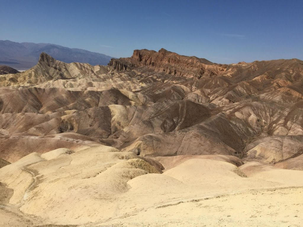Brown cliffs with golden sand at Death Valley