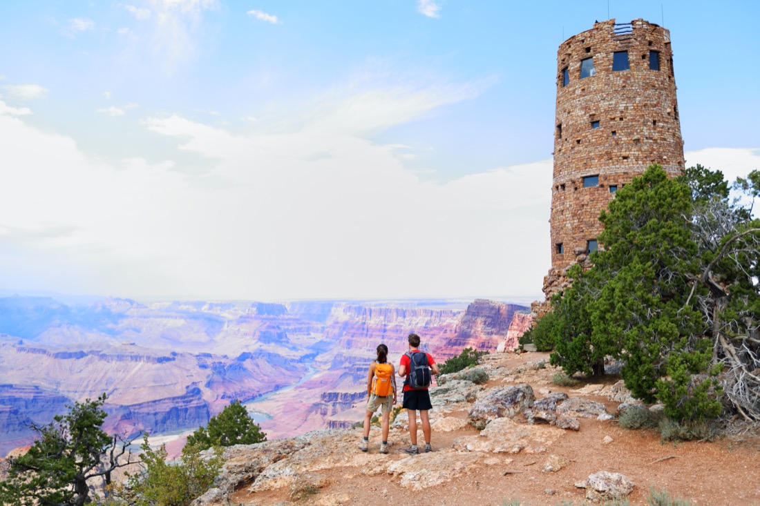 Couple stands at Desert View Watchtower South Rim of the Grand Canyon