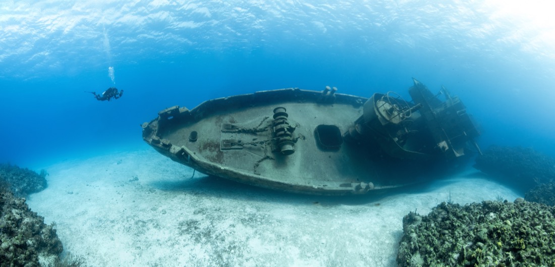 The Scuba divers examining the famous USS Kittiwake submarine wreck in the Grand Cayman Islands
