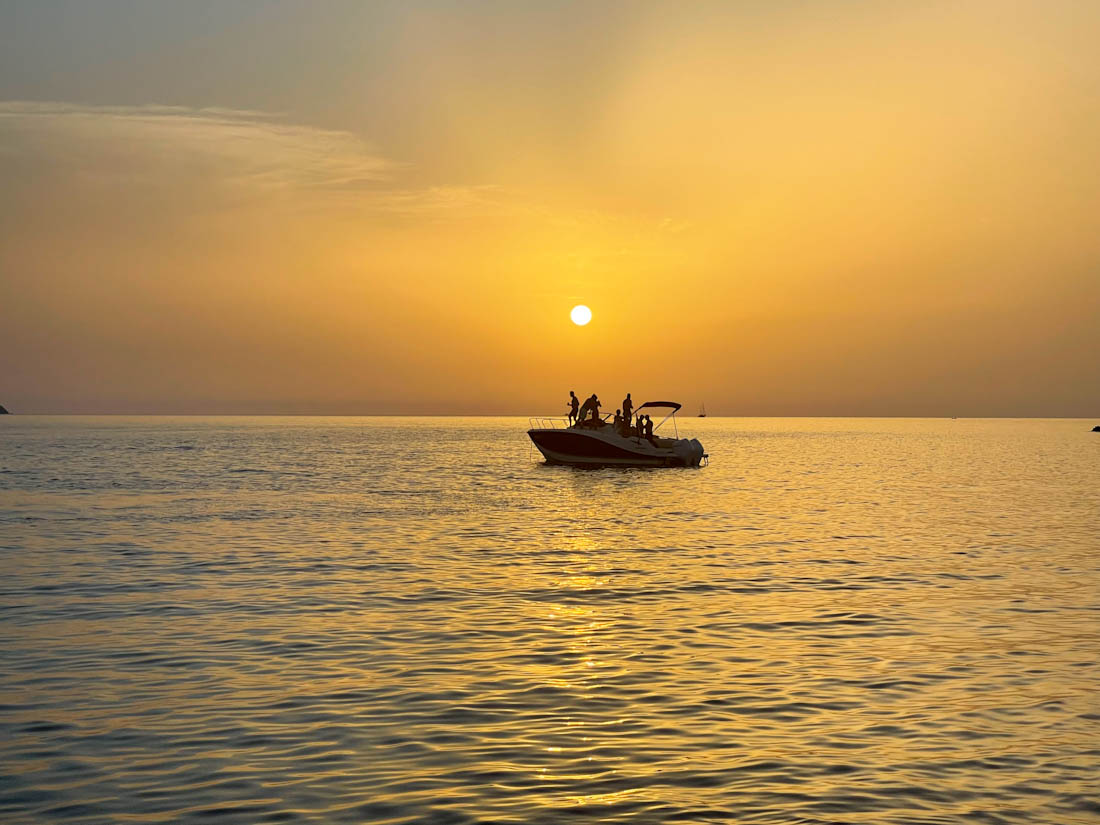 Boat silhouette against sunset in Ibiza