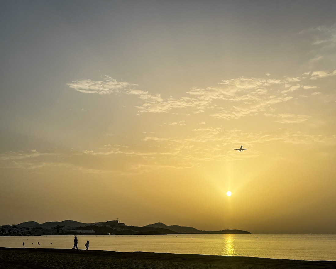 Sunrise at Playa Den Bossa with Plane flying over Ibiza