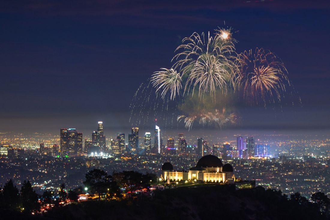 Fogos de artifício piscando e a paisagem urbana de Lost Angeles à noite.