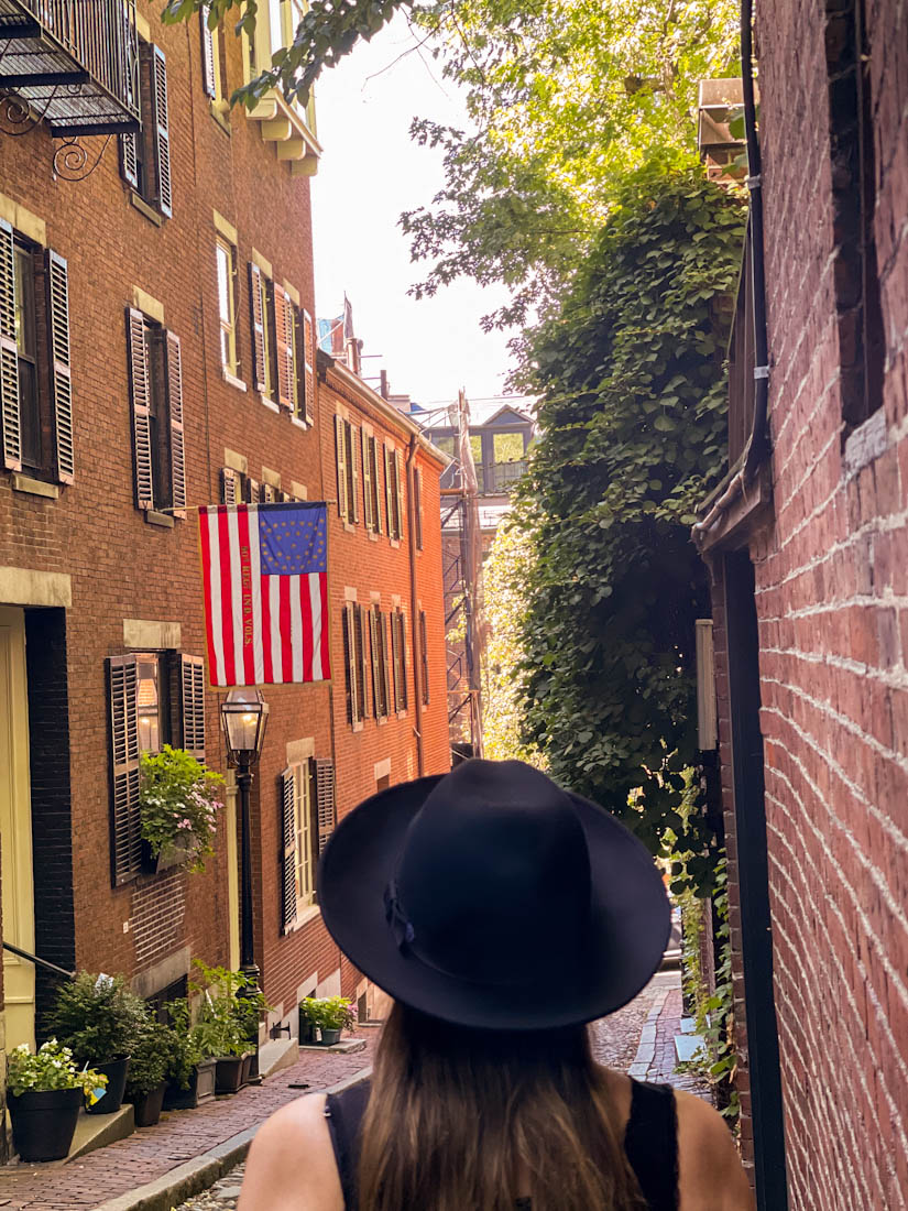 Woman in hat looking at Acorn Street at Beacon Hill in Boston Massachusetts