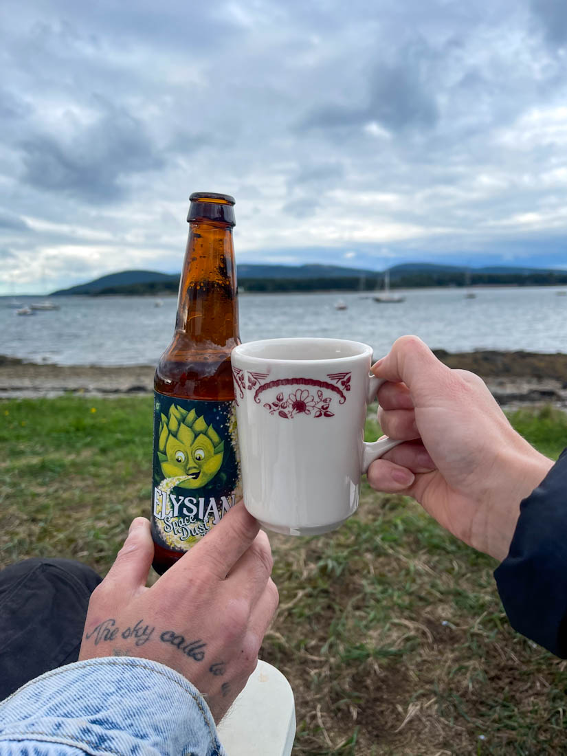 Beer, cup doing a cheers motion at Southwest Harbor area Acadia National Park Mount Desert Island Maine
