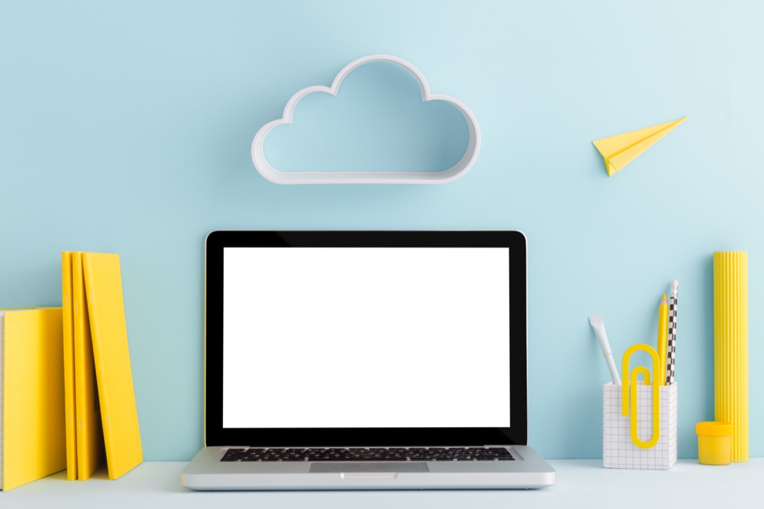 Laptop with cloud above it on blue background. 