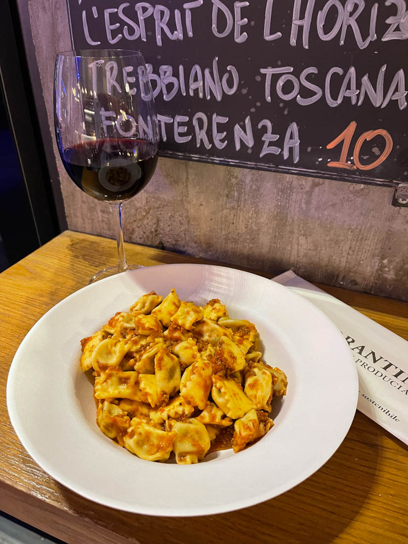 Plate of pasta and glass of wine at Mercato Centrale Milano