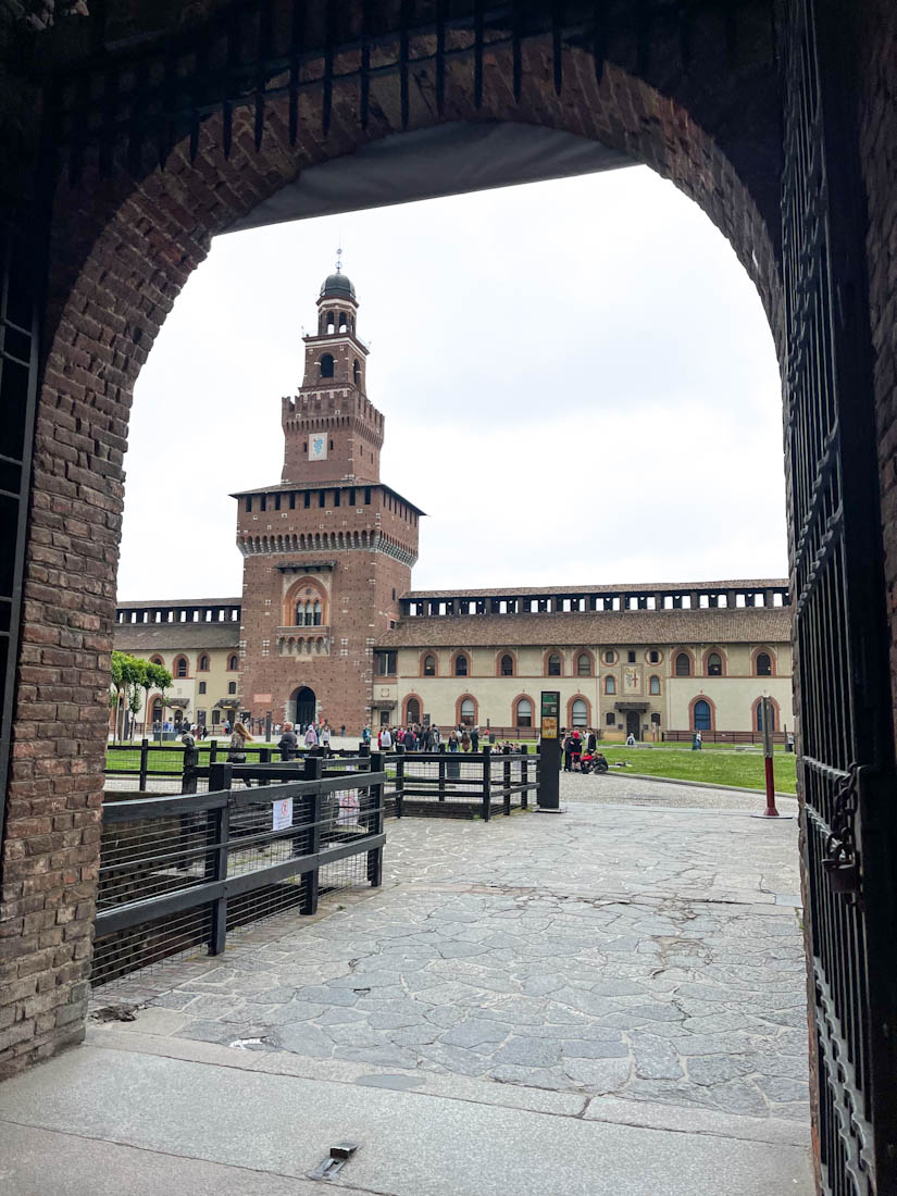Sforzesco Castle framed by arch in Sempione Park Milan Italy